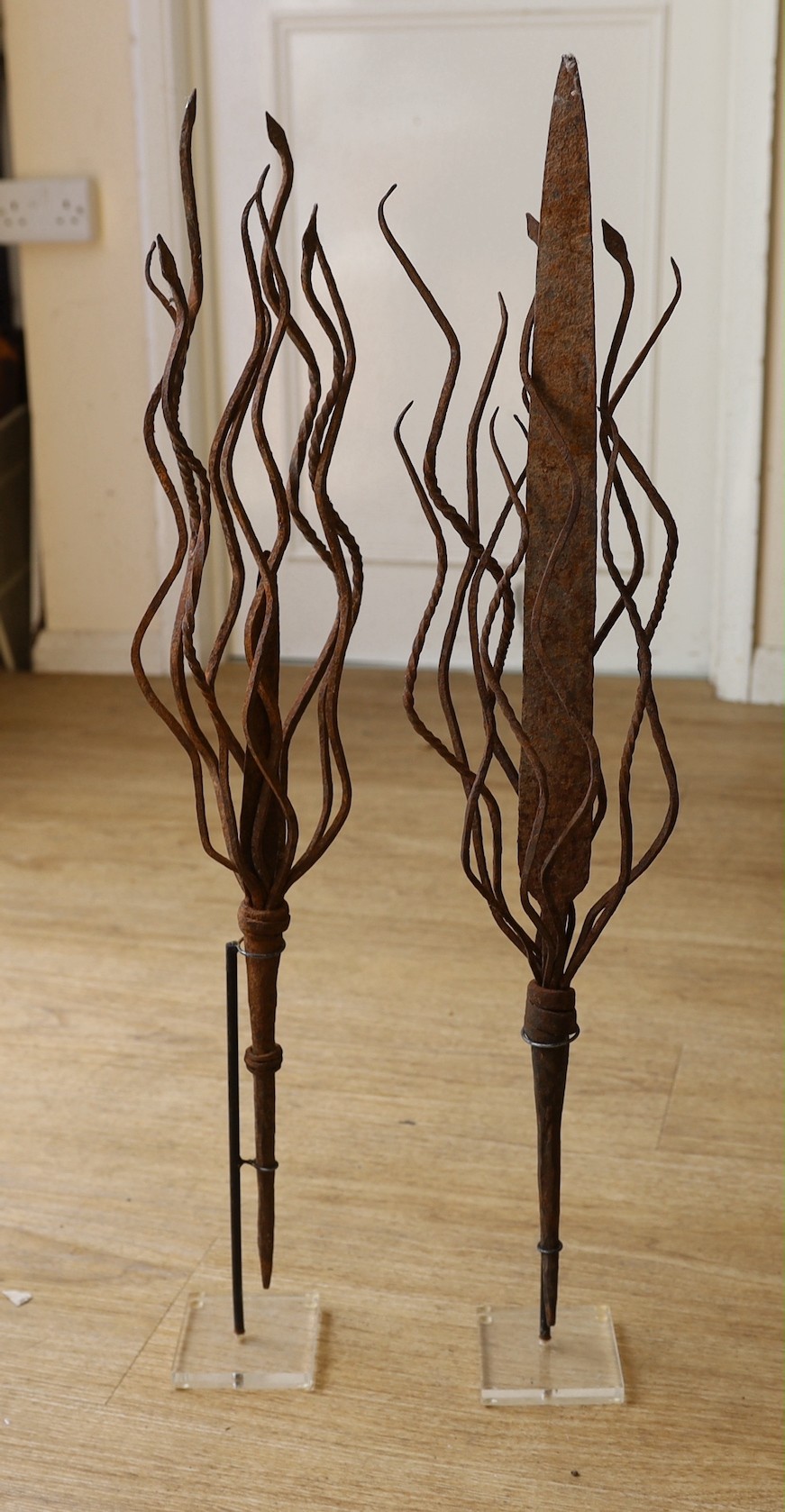 Two African wrought iron currency blades, on Perspex stands, 70 cms high including stands.